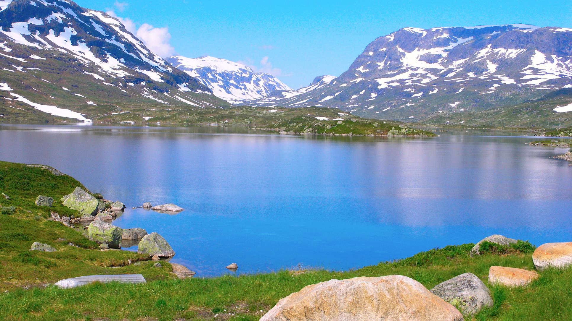Norska fjäll med en tjärn i förgrunden
